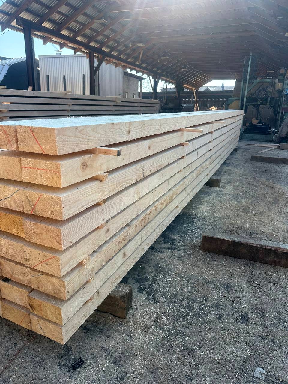 Long wooden beams stacked at production warehouse